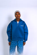 Découvre l’ensemble streetwear bleu Syttiz : sweat à col zippé et pantalon dégradé bleu/blanc. Style urbain, coupe oversize et confort premium signé Syttiz.