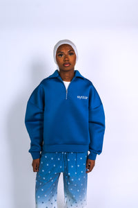 Découvre l’ensemble streetwear bleu Syttiz : sweat à col zippé et pantalon dégradé bleu/blanc. Style urbain, coupe oversize et confort premium signé Syttiz.